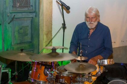 Músico octagenário continua a praticar desporto e nada o faz largar a bateria. Plínio Ferrão é também um dos últimos da sua geração no ativo.