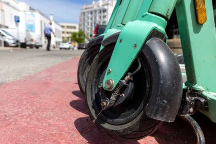 Trotinetes elétricas a circular em contexto urbano com trânsito misto.