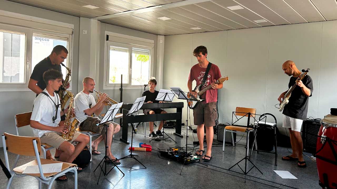 Lagos Music Summer Camp termina com jovens músicos no palco principal do LAGOS MMFEST’26, após cinco dias de formação intensiva. Durante cinco dias, os participantes terão aulas de instrumento, ensaios de combo, improvisação, workshops e masterclasses, num programa orientado para a criação artística, a experimentação musical e a performance ao vivo. A edição de 2026 reúne músicos e docentes com experiência nacional e internacional, nas áreas da voz, saxofone, guitarra, piano, baixo, contrabaixo, trompete, trombone e bateria. Entre os formadores estão Marta Rodrigues, Lucas Hardy, Cátia Ribeiro, Ana Albino, Léo Vrillaud, Francisco Nogueira, Néstor Díaz e Sebastião Bergmann. O programa inclui ainda masterclasses dedicadas à introdução ao DJing, às redes sociais como portefólio artístico e aos fundamentos de ritmo e harmonia. A inscrição inclui alojamento na EB 2,3 Tecnopolis, em Lagos, refeições durante o período do Summer Camp, transporte para os locais dos concertos e participação no concerto final integrado no LAGOS MMFEST’26. Os participantes terão também participação no concerto da Orquestra Ligeira de Lagos. As vagas são limitadas e as inscrições decorrem por ordem de receção até 1 de agosto. As informações estão disponíveis através do Instagram do LAGOS MMFEST e da página Linktree do festival.