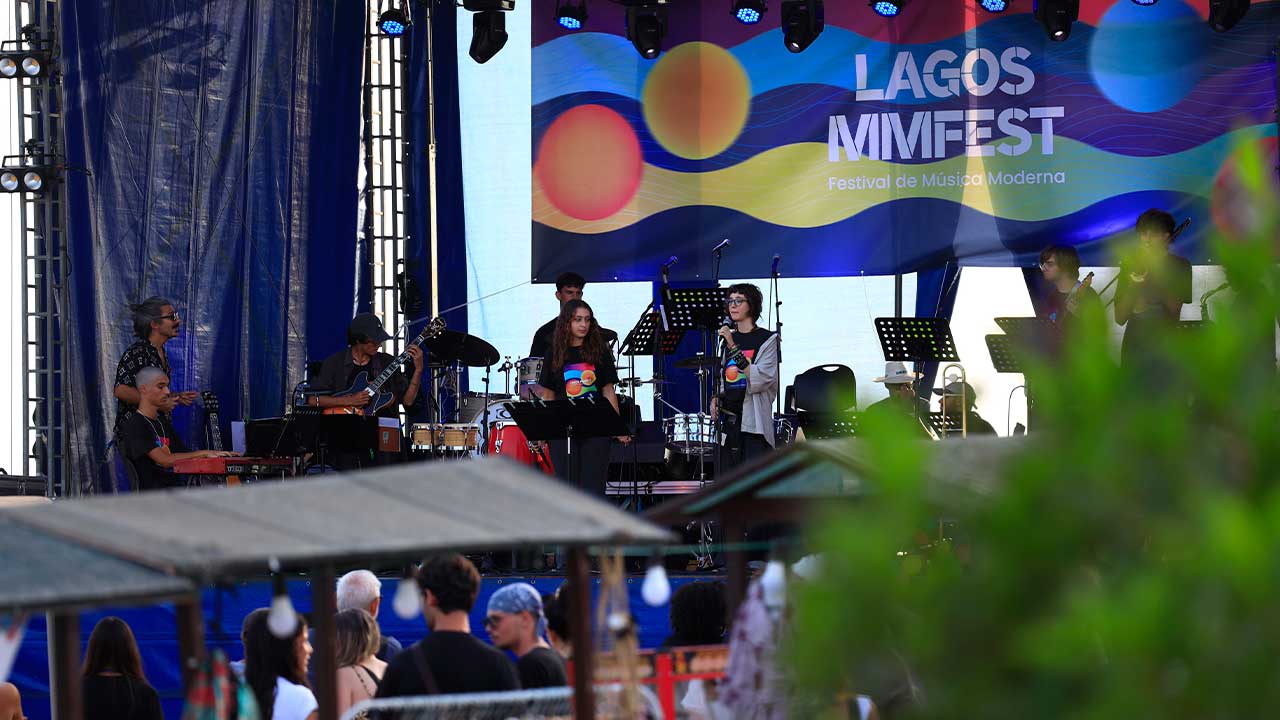 Lagos Music Summer Camp termina com jovens músicos no palco principal do LAGOS MMFEST’26, após cinco dias de formação intensiva. Durante cinco dias, os participantes terão aulas de instrumento, ensaios de combo, improvisação, workshops e masterclasses, num programa orientado para a criação artística, a experimentação musical e a performance ao vivo. A edição de 2026 reúne músicos e docentes com experiência nacional e internacional, nas áreas da voz, saxofone, guitarra, piano, baixo, contrabaixo, trompete, trombone e bateria. Entre os formadores estão Marta Rodrigues, Lucas Hardy, Cátia Ribeiro, Ana Albino, Léo Vrillaud, Francisco Nogueira, Néstor Díaz e Sebastião Bergmann. O programa inclui ainda masterclasses dedicadas à introdução ao DJing, às redes sociais como portefólio artístico e aos fundamentos de ritmo e harmonia. A inscrição inclui alojamento na EB 2,3 Tecnopolis, em Lagos, refeições durante o período do Summer Camp, transporte para os locais dos concertos e participação no concerto final integrado no LAGOS MMFEST’26. Os participantes terão também participação no concerto da Orquestra Ligeira de Lagos. As vagas são limitadas e as inscrições decorrem por ordem de receção até 1 de agosto. As informações estão disponíveis através do Instagram do LAGOS MMFEST e da página Linktree do festival.